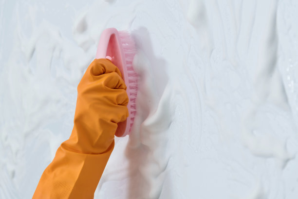 女人用刷子清洗蓝色的墙壁图片下载