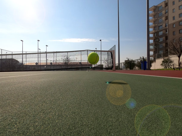 黄色网球落在没有人的低角度视角与镜头光晕图片下载