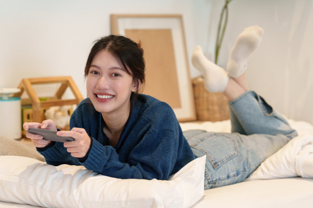 在智能手机上玩游戏的年轻女人图片下载