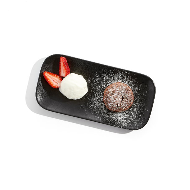 巧克力翻糖和冰淇淋球在黑色盘子。传统的法式甜点——巧克力蛋糕配冰淇淋和草莓。熔岩饼孤立在白色背景。热可可布丁。图片下载