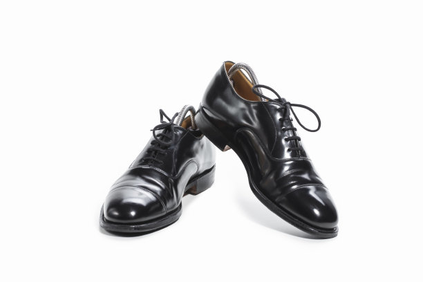 鞋的概念。一双正式的男性时尚黑色抛光牛津皮革花边鞋放在一起在白色。图片下载