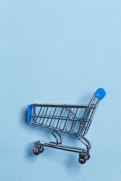 空推车设计购物或销售概念。购物车放置在时尚的蓝色背景与文字空间。图片下载