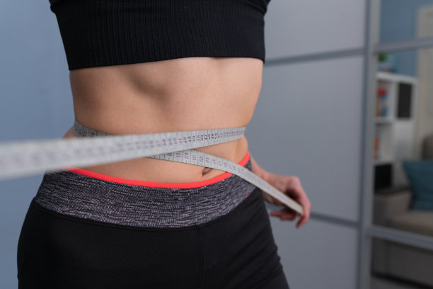 苗条的女人在测量她的细腰图片下载