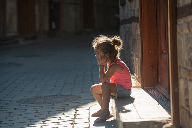 女孩坐在户外门口的肖像图片下载