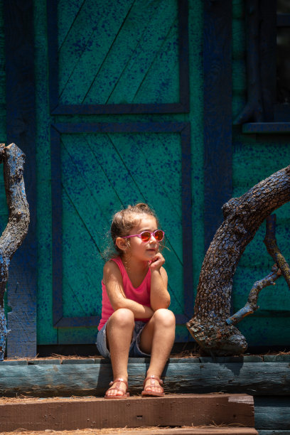 女孩坐在户外门口的肖像图片下载