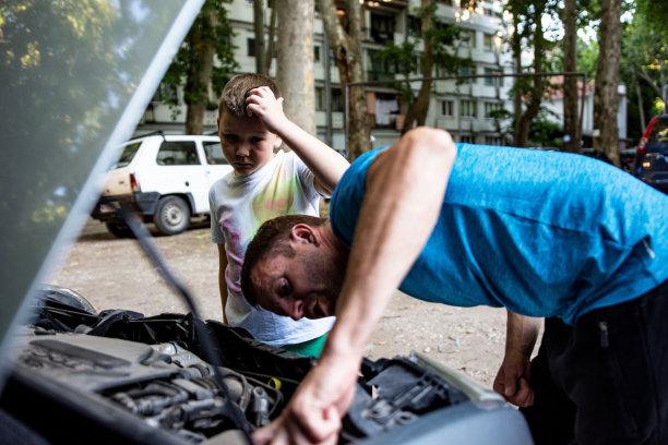 父亲和儿子修理一辆汽车图片下载