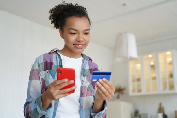 快乐少年用信用卡消费。网上购物、电子商务和消费主义。图片下载