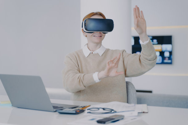 女孩戴着3d眼镜坐在桌子前的笔记本电脑前。现代设备使用的概念。图片下载