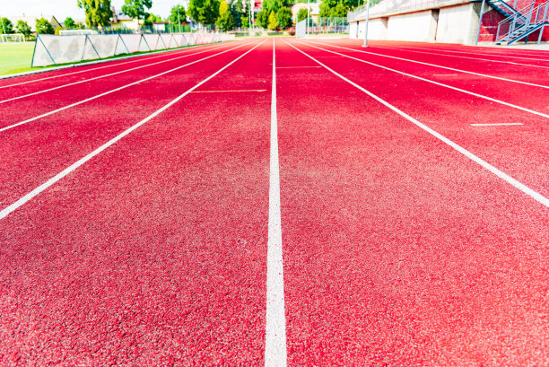 田径跑道，红色表面和白色线条特写。图片下载