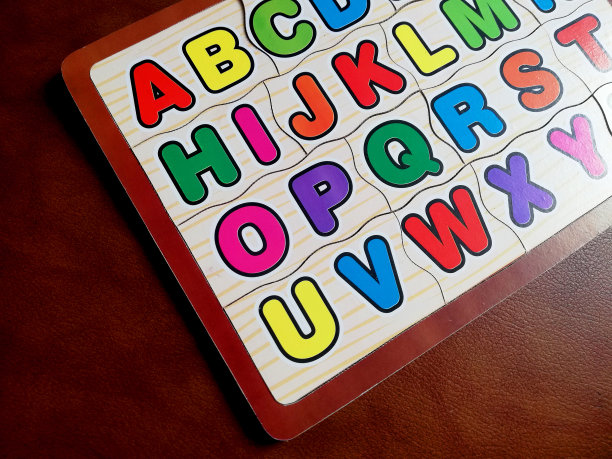 彩色字母拼图为孩子，孤立在棕色背景图片下载