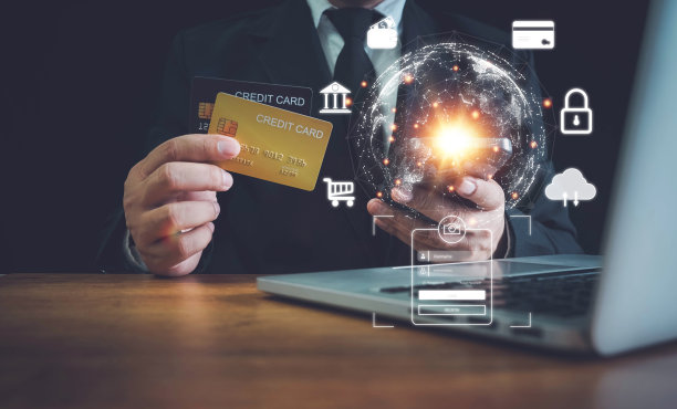 网上支付，男人手里拿着信用卡，用笔记本电脑，商人在电脑上用信用卡在网上购物，网上信用卡支付从网上购买的商品。图片下载