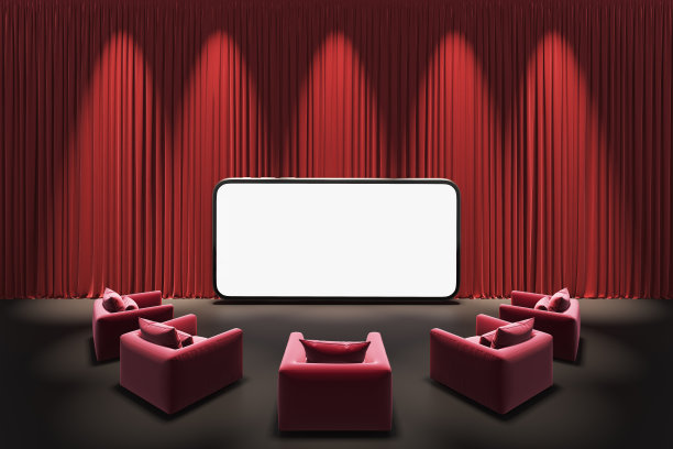 剧院舞台的幕布展示聚光灯。在红色沙发或扶手椅上用智能手机观看在线娱乐媒体电影。图片下载