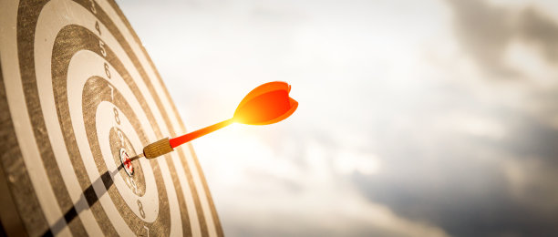 近距离射击红色飞镖箭在靶心的靶标在深蓝色的天空背景。企业目标或目标成功与赢家的概念。图片下载