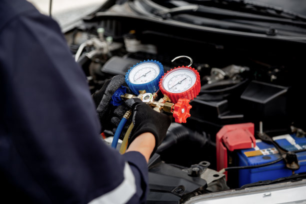 近手的汽车技师使用测量歧管仪表检查制冷剂和填充汽车空调修理和检查维修服务支持维修和汽车保险。图片下载