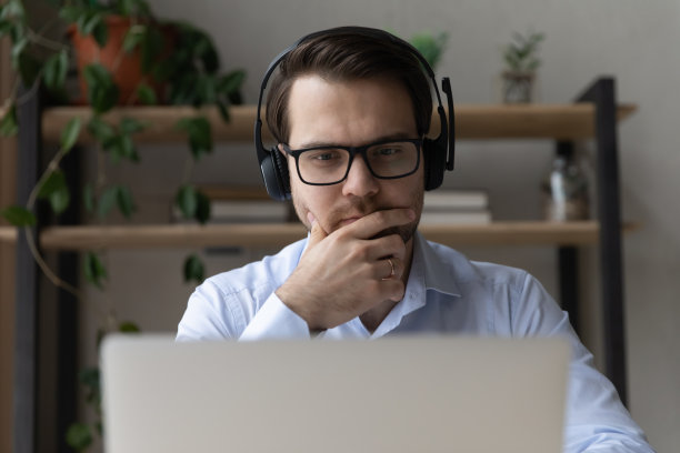 在办公室从事计算机工作的年轻商人。图片下载