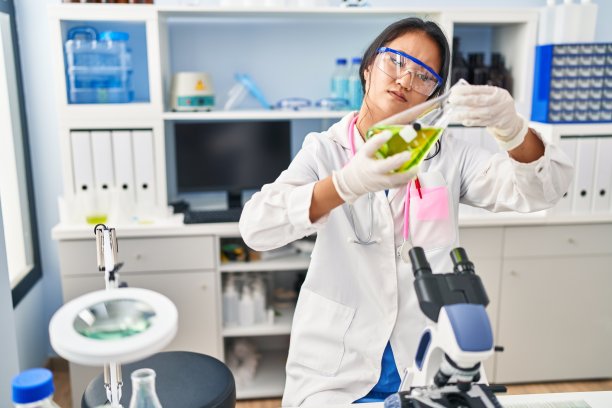 身穿科学家制服的中国年轻女子在实验室手持试管图片下载