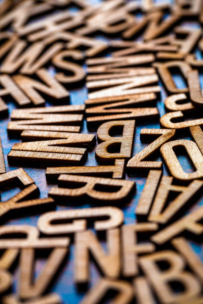 木制字母瓷砖分散在蓝色金属表面图片下载