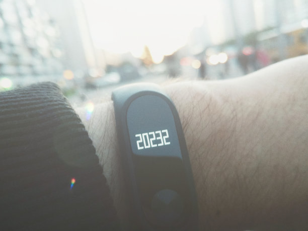 手握健身活动跟踪计步器手环，每天多步!心率监视器。复古色调，镜头光晕。图片下载