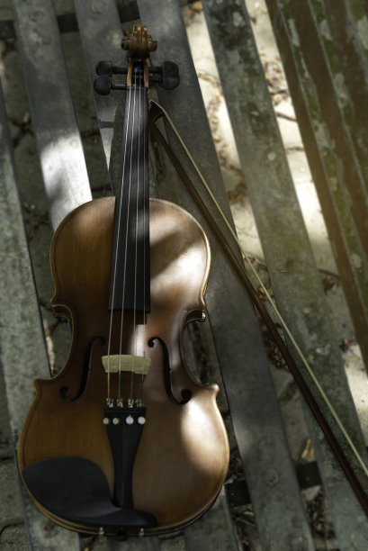 小提琴和中提琴放在场地的长凳上，在练习休息时间为音乐会做准备。图片下载