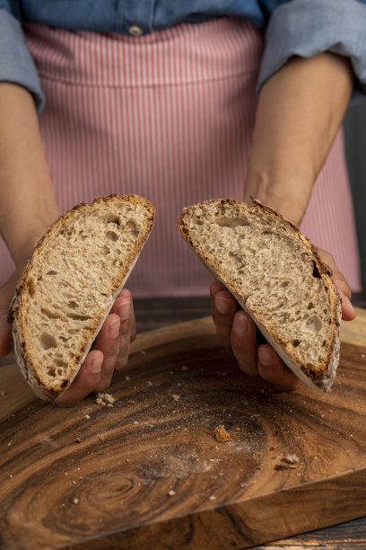 拿着刚烤好的面包的女人。- - -库存图片图片下载