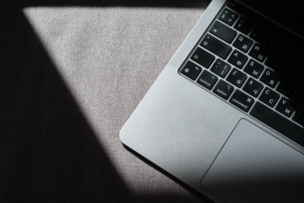 特写的笔记本电脑键盘在阳光下放在桌子上，背光键盘图片下载