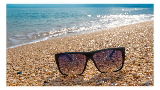 夏天在沙滩上戴墨镜。沙滩上时髦的塑料镜框眼镜。镜框推广。视讯商店出售。图片下载