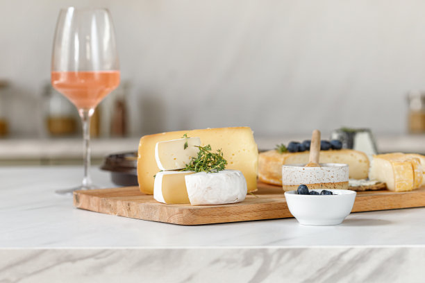 法国奶酪和意大利奶酪。奶酪和葡萄酒的概念。木制砧板上放着卡门贝尔奶酪，还有水果和蜂蜜。奶酪板、菜。厨房的背景。图片下载