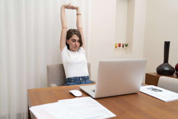 女性在家办公时伸展身体图片下载