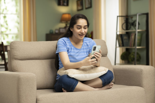 微笑的漂亮年轻女人在用手机应用。库存图片图片下载