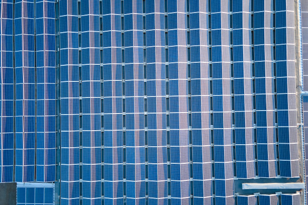 工业建筑屋顶安装的蓝色光伏太阳能电池板，用于生产绿色生态电力。生产可持续能源的理念图片下载