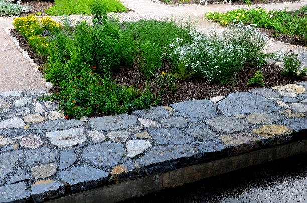 在公园里有规则形状的池塘上方铺设的粗糙的石灰石。tralk床。灰色和棕色混合的扁平石瓦图片下载