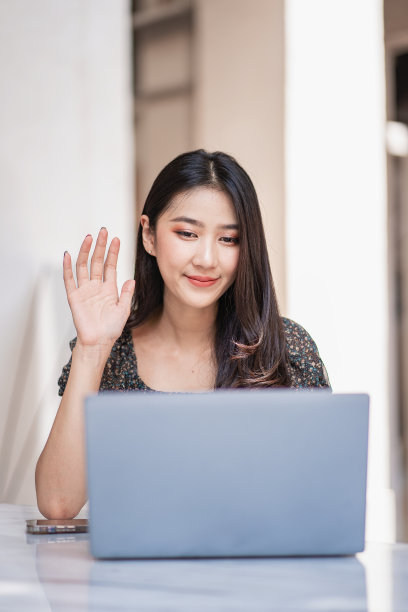 穿着休闲服装的亚洲女性在户外工作愉快地在我的个人笔记本电脑上工作和上网。图片下载