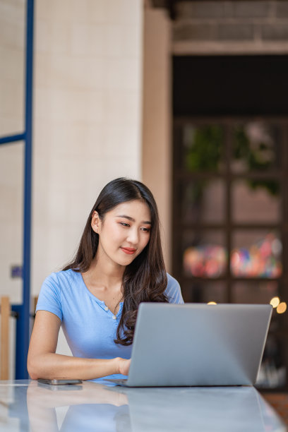 穿着休闲服装的亚洲女性在户外工作愉快地在我的个人笔记本电脑上工作和上网。图片下载