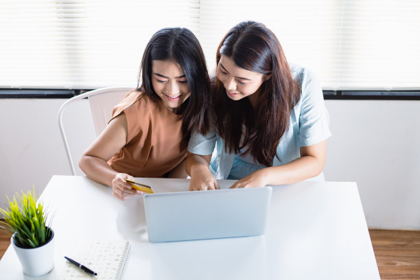 亚洲女性和她的朋友们以一种有趣和无忧无虑的方式在网上购物。图片下载