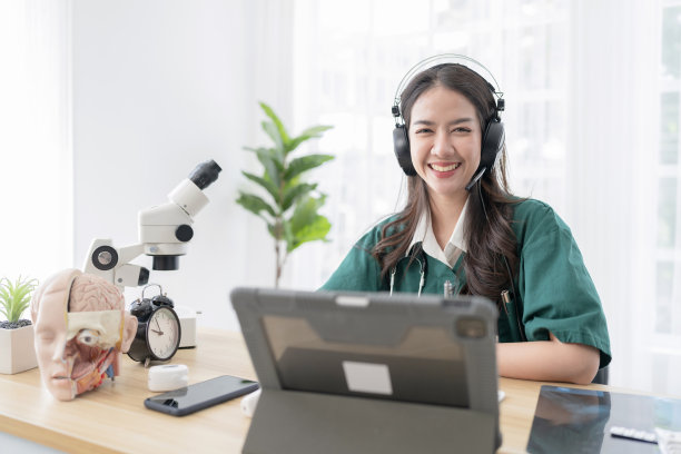 年轻迷人的亚洲女医生诊断说，并看着镜头在视频会议，积极的医生挥手，并在数字平板电脑上进行在线咨询图片下载