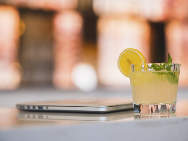 吧台上放着一杯鸡尾酒和一台笔记本电脑图片下载