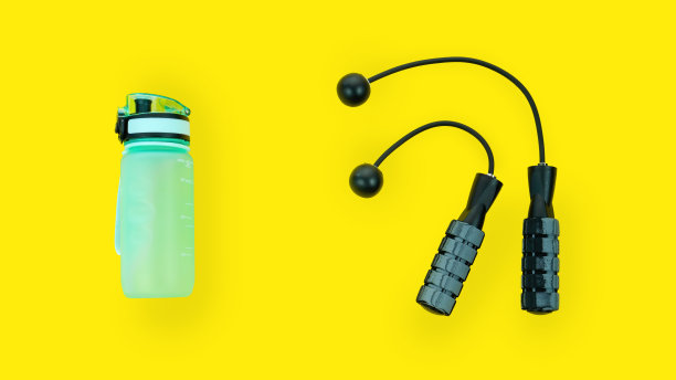 无绳跳绳和蓝色水瓶孤立在黄色背景。运动配件，健康生活方式。以饮料瓶和跳绳为理念的健康生活方式。图片下载