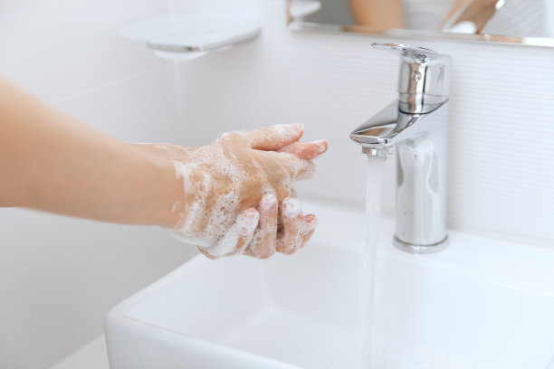 在水龙头下洗手。卫生概念手细节。勤洗手，用肥皂搓手，防止冠状病毒在公共厕所或公共厕所传播图片下载