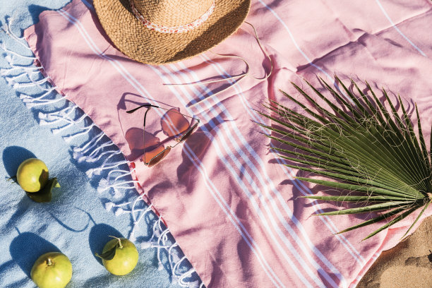 夏季海滩配件平躺在沙的背景。假日旅行，热带概念。草帽，太阳镜，毛巾和水果。太阳阴影和阳光图片下载