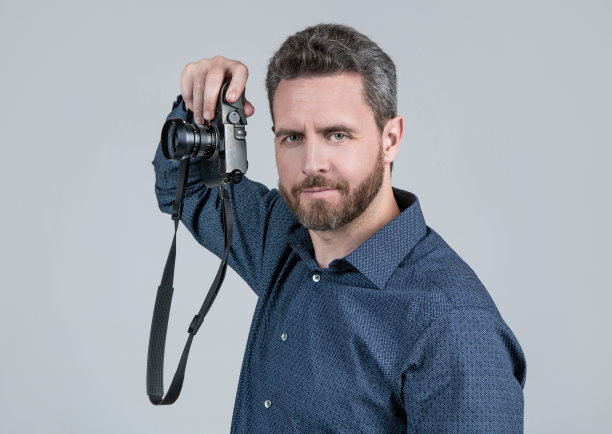 摄影是我的爱好。胡子拉碴的男人拿着相机。爱好的概念图片下载