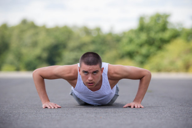 一个19岁的少年在公园里做俯卧撑图片下载