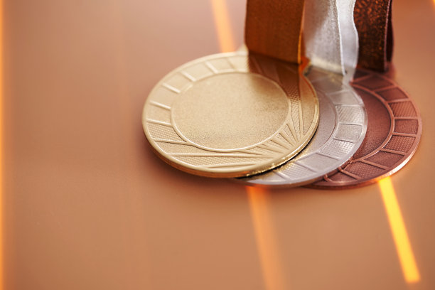 特写金，银和铜牌对橙色背景图片下载