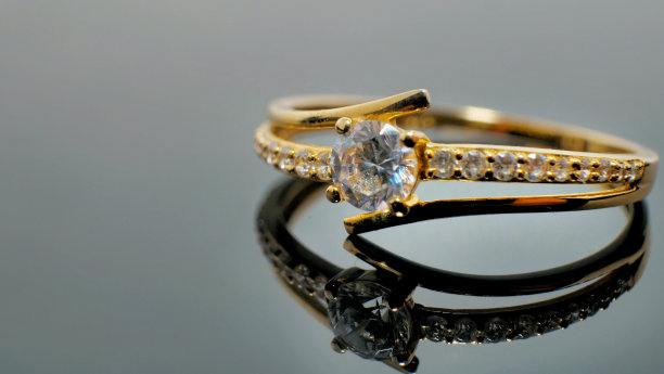 黄金珠宝戒指与钻石在反射光的黑色表图片下载