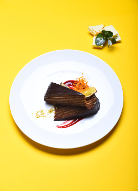 盘子里的布拉格巧克力蛋糕，黄色背景。图片下载