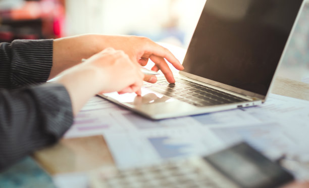 特写照片的商务人士在办公室工作与笔记本电脑和智能手机和图形数据。图片下载