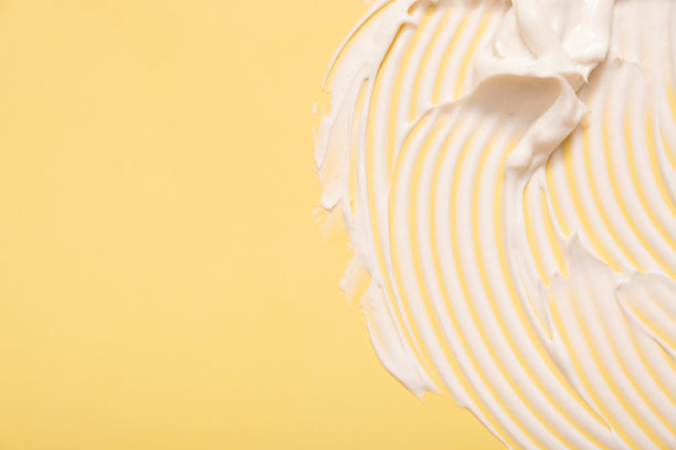 特写润肤霜涂抹涂抹波浪纹理彩色背景与拷贝空间水平格式。护肤美容产品图片下载