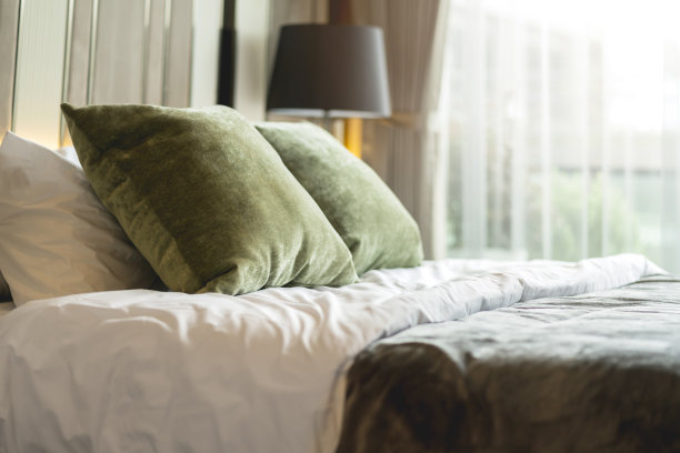 卧室室内设计近观，家居室内概念软枕布置在卧室大尺寸白色毛毯床垫上，以白色窗帘为背景的家居温馨家居室内理念图片下载