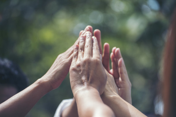 多元化多民族的击掌团商务人士成功团队携手共进。协作志愿者友谊双手举起使命商业伙伴。一组团队一起击掌图片下载