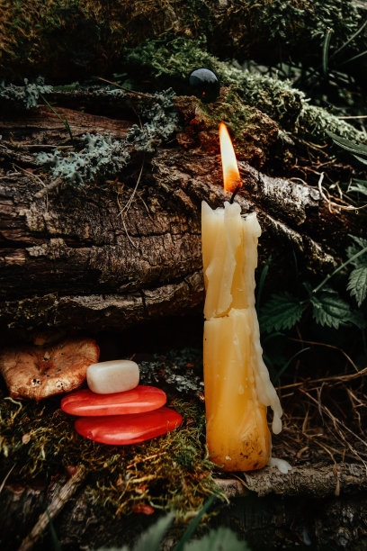 燃烧着的蜡烛，象征着月亮，石头躺在一块苔藓上，背景是黑暗的自然。异教徒巫术，斯拉夫传统。巫术，深奥的精神仪式。秋分节图片下载