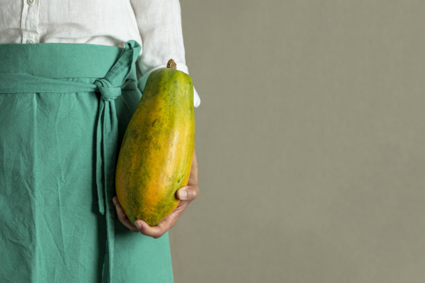 妇女手持木瓜在当地市场-库存照片图片下载